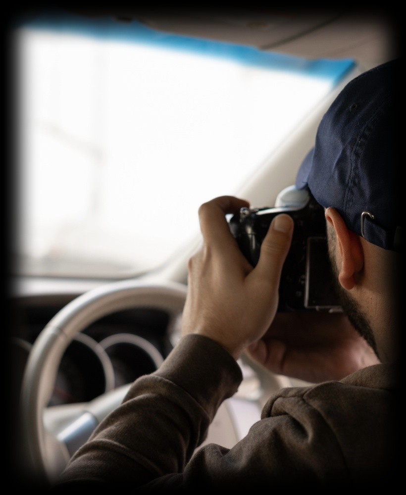 A private investigator on a divorce case holding a camera