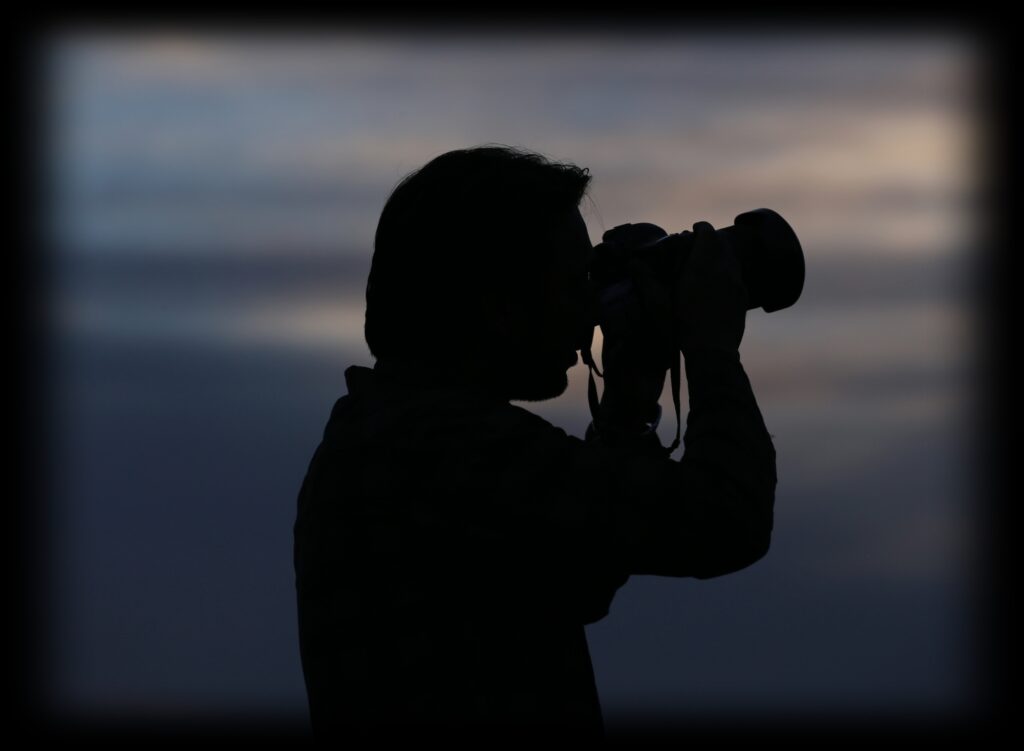 A private investigator taking a photograph